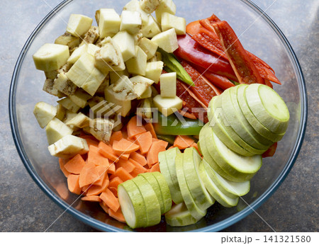 a glass bowl: eggplant, zucchini, red and green bell peppers and carrot a glass bowl: eggplant, zucchini, red and green bell peppers and carrot 141321580