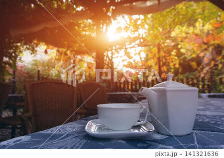 teapot with cup on table at park outdoor, fresh breakfast at sunset teapot with cup on table at park outdoor, fresh breakfast at sunset 141321636