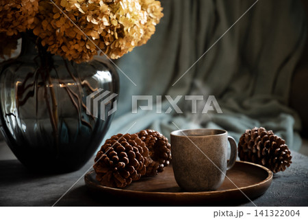Steaming coffee with hydrangea and pine cone Steaming coffee with hydrangea and pine cone 141322004