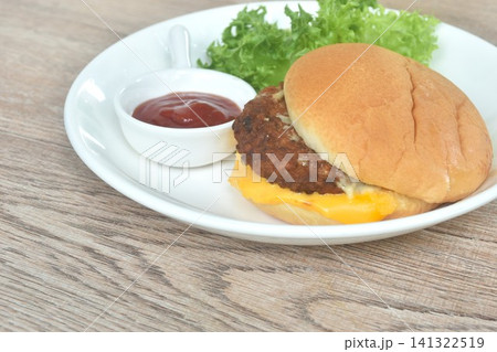 fried mashed beef cheeseburger and fresh vegetable salad with ketchup on plate fried mashed beef cheeseburger and fresh vegetable salad with ketchup on plate 141322519