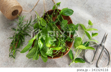 Fresh herbs from garden on rustic surface with scissors 141324118