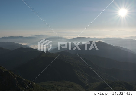 太陽の光条が美しく降り注ぐ、快晴の朝の山並みと雲海の絶景 太陽の光条が美しく降り注ぐ、快晴の朝の山並みと雲海の絶景 141324416