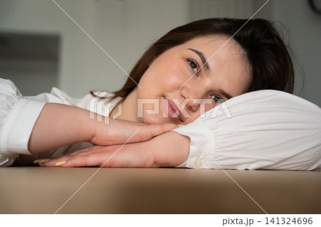 Tired woman resting her head on a table while working remotely from home. Stress management and mental wellness during remote work fatigue Tired woman resting her head on a table while working remotely from home. Stress management and mental wellness during remote work fatigue 141324696
