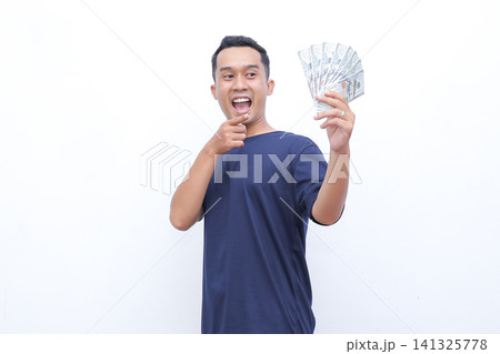 Man beams joyfully, flexing arm proudly. He holds money in one hand, smiling widely. Studio lighting highlights his enthusiastic expression. Perfect for business, finance, or success-themed projects Man beams joyfully, flexing arm proudly. He holds money in one hand, smiling widely. Studio lighting highlights his enthusiastic expression. Perfect for business, finance, or success-themed projects 141325778