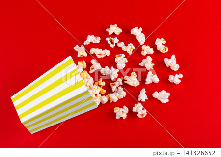 box with popcorn striped in different colors on a red background box with popcorn striped in different colors on a red background 141326652