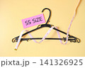 A measuring tape around Clothes hanger on color background, top view. 141326925