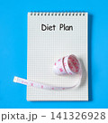 A measuring tape around notebook for diet plan. 141326928