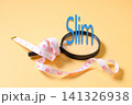 A measuring tape around magnifying glass and text SLIM . 141326938