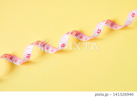 White color measuring tape on color background, top view. White color measuring tape on color background, top view. 141326940