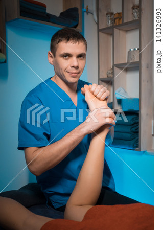 masseur making healing foot massage for woman spine masseur making healing foot massage for woman spine 141326993