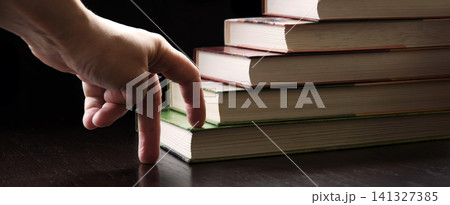 Hand walking on a ladder made of books 141327385