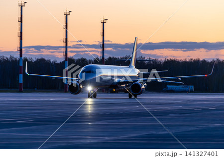 Modern passenger aircraft taxiing at the airport early in the morning Modern passenger aircraft taxiing at the airport early in the morning 141327401