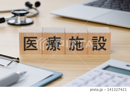 デスクの上に医療施設と書かれた積み木のブロック　医療イメージ 141327421