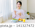 朝食でヨーグルトを食べる若い女性 朝食でヨーグルトを食べる若い女性 141327472