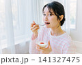 朝食でヨーグルトを食べる若い女性 朝食でヨーグルトを食べる若い女性 141327475