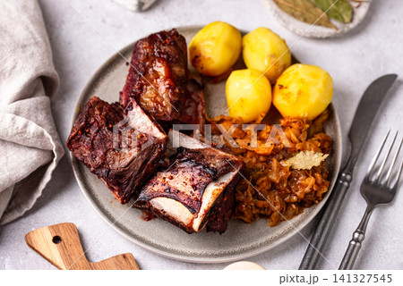 Grilled ribs with sauerkraut and potatoes 141327545