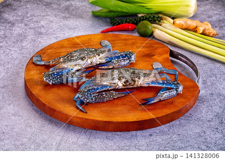 Fresh blue crabs on wooden cutting board with lemongrass chili lime ginger 141328006