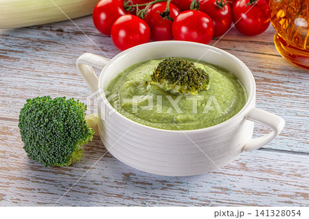 Broccoli soup in white bowl with fresh vegetables on rustic wooden table Broccoli soup in white bowl with fresh vegetables on rustic wooden table 141328054
