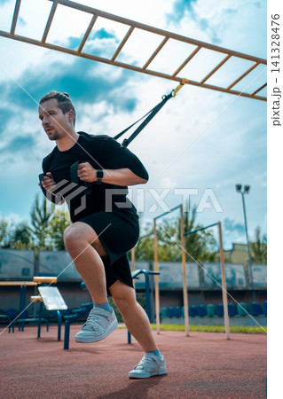 yound sporty athlete or bodybuilder has fitness workout with trx outdoor yound sporty athlete or bodybuilder has fitness workout with trx outdoor 141328476