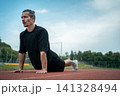 athletic sportsman has workout or planking and stretching outdoor 141328494