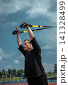 yound sporty athlete or bodybuilder has fitness workout with trx outdoor 141328499