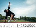 muscle athlete training and doing stretch exercises outdoor 141328500