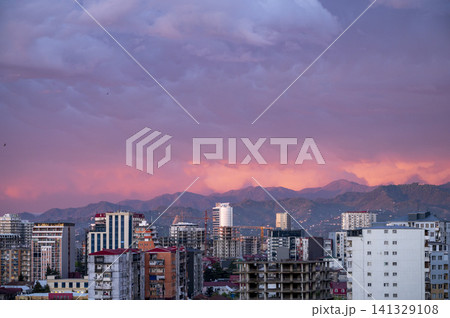 City skyline with mountains at sunset in warm colorful evening light. City skyline with mountains at sunset in warm colorful evening light. 141329108