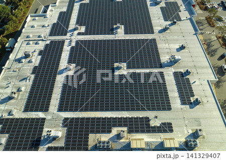 Aerial view of solar power plant with blue photovoltaic panels mounted on industrial building roof for producing green ecological electricity. Production of sustainable energy concept Aerial view of solar power plant with blue photovoltaic panels mounted on industrial building roof for producing green ecological electricity. Production of sustainable energy concept 141329407