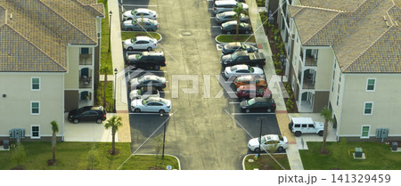Aerial view of cars parked on parking places at american apartment building in Florida residential area. New family condos as example of housing development in US suburbs Aerial view of cars parked on parking places at american apartment building in Florida residential area. New family condos as example of housing development in US suburbs 141329459