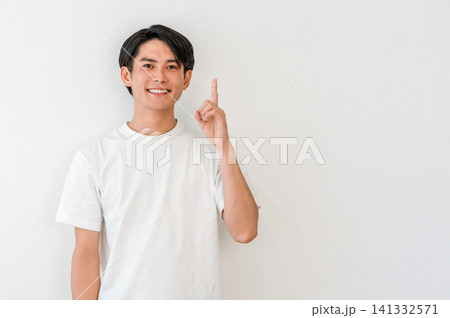 指差しするTシャツ姿の若いアジア人男性(ポイント,紹介,案内,ガイド,おすすめ,誘導) 指差しするTシャツ姿の若いアジア人男性(ポイント,紹介,案内,ガイド,おすすめ,誘導) 141332571