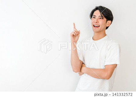 指差しするTシャツ姿の若いアジア人男性(ポイント,紹介,案内,ガイド,おすすめ,誘導) 指差しするTシャツ姿の若いアジア人男性(ポイント,紹介,案内,ガイド,おすすめ,誘導) 141332572
