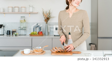 キッチンで朝食にパンをカットする女性 キッチンで朝食にパンをカットする女性 141332913