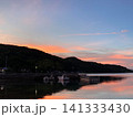 夕焼けに染まる静かな港と茜色の穏やかな海 141333430