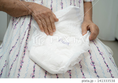 Asian senior woman patient wearing adult incontinence diaper pad in hospital. 141333538