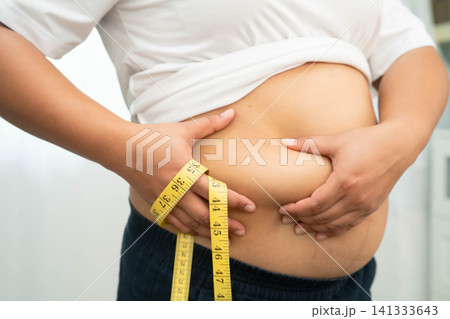 Asian woman use hand to squeeze fat belly big size overweight and obesity. Asian woman use hand to squeeze fat belly big size overweight and obesity. 141333643