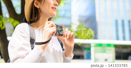 カメラを持つ女性、街歩きを楽しむ 141333785
