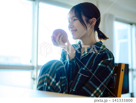 りんごを持つ女性、パジャマ姿でリラックスした朝のひととき りんごを持つ女性、パジャマ姿でリラックスした朝のひととき 141333800