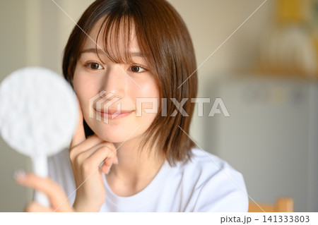 女性が鏡で肌チェックをする様子 女性が鏡で肌チェックをする様子 141333803