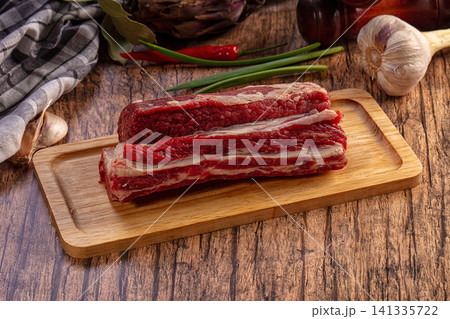 Raw beef short ribs with garlic chili green onions on wooden board Raw beef short ribs with garlic chili green onions on wooden board 141335722