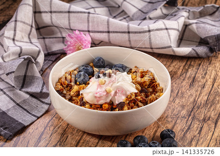 Granola bowl with blueberries yogurt and chocolate balls on wooden table Granola bowl with blueberries yogurt and chocolate balls on wooden table 141335726