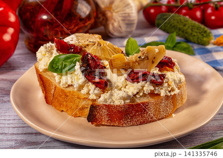 Bruschetta with ricotta, sun-dried tomatoes, artichoke hearts, and basil on rustic plate Bruschetta with ricotta, sun-dried tomatoes, artichoke hearts, and basil on rustic plate 141335746