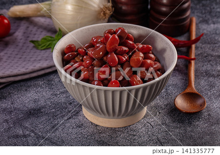 Red kidney beans in ceramic bowl with onion and spices on dark stone table Red kidney beans in ceramic bowl with onion and spices on dark stone table 141335777