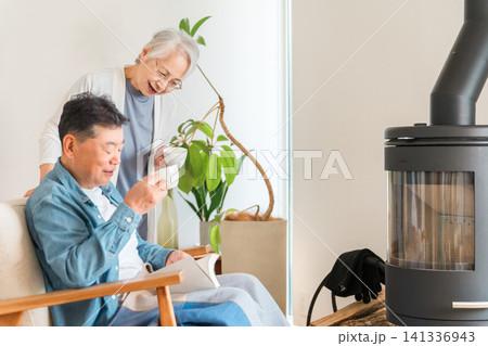 リビングでコーヒーを飲みながらくつろぐシニア夫婦 141336943