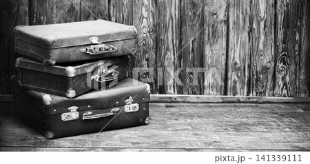Wooden background with three suitcases Wooden background with three suitcases 141339111