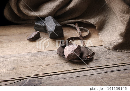 An antique leather sling lies on wooden desk An antique leather sling lies on wooden desk 141339146