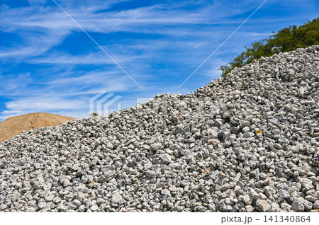 青空の下に積まれた大量の砕石・砂利の山 青空の下に積まれた大量の砕石・砂利の山 141340864