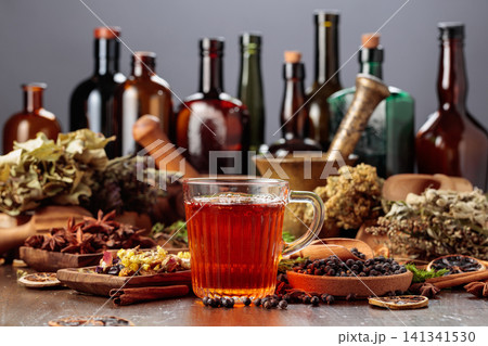 Herbal tea on an old wooden table with dried herbs, fruit, and spices. Herbal tea on an old wooden table with dried herbs, fruit, and spices. 141341530
