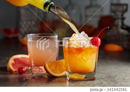 Orange juice poured into a glass with ice. Orange juice poured into a glass with ice. 141341591