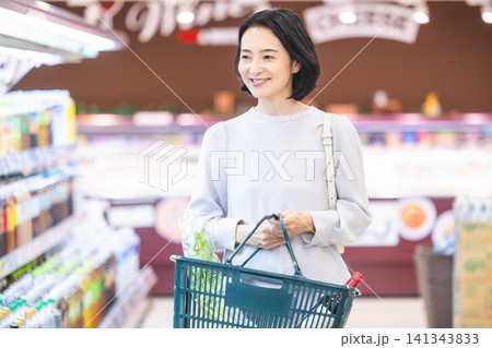 スーパーで買い物をする女性買い物客 スーパーで買い物をする女性買い物客 141343833