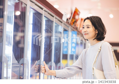 冷凍食品コーナーで商品を選ぶ主婦 141343838